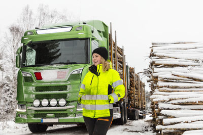 Smiling woman standing in front of lorry