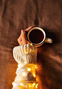 Christmas lights and coffee. cozy atmosphere is created with cup of coffee and christmas lights.