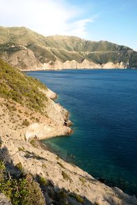 Scenic view of sea and mountains against sky