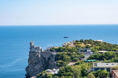 Scenic view of sea and buildings against clear sky