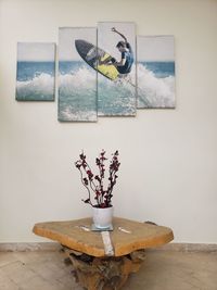 Flower vase on table against wall at home