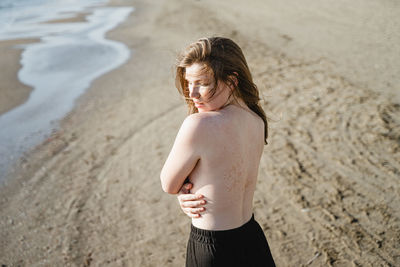Portrait of young woman standing at beach