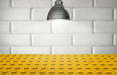 Close-up of yellow lamp against wall