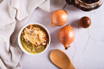 Homemade onion soup with croutons and cheese in a bowl on the table top view