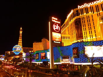 Illuminated buildings in city against sky at night