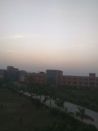 Buildings in city against sky at sunset