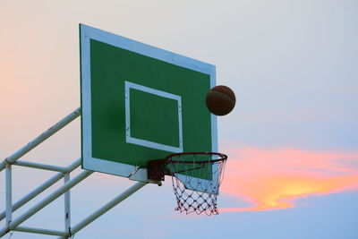 Low angle view of basketball hoop against sky during sunset