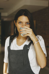 Portrait of beautiful woman standing against wall