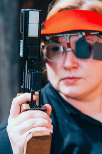 Close-up of woman practicing target shooting with pistol