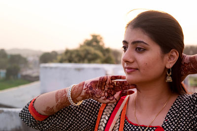 Young woman with henna tattoo looking away