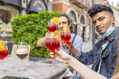 Portrait of friends holding drinks