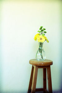 Close-up of vase on table against wall