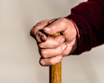 Close-up of man holding hands over white background