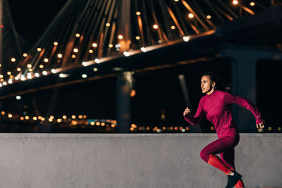 Full length of woman on illuminated city at night