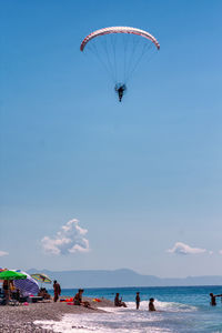 People enjoying at beach against sky