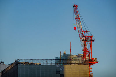 Low angle view of crane against clear sky