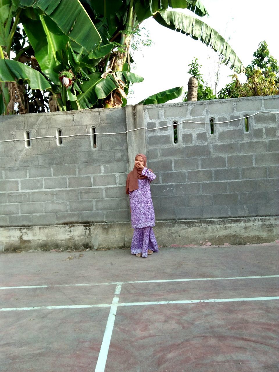 GIRL STANDING AGAINST TREES