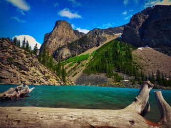 Scenic view of lake and mountains against blue sky