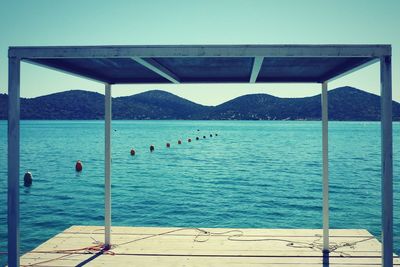 Swimming pool by sea against sky