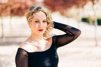 Portrait of beautiful woman standing against blurred background