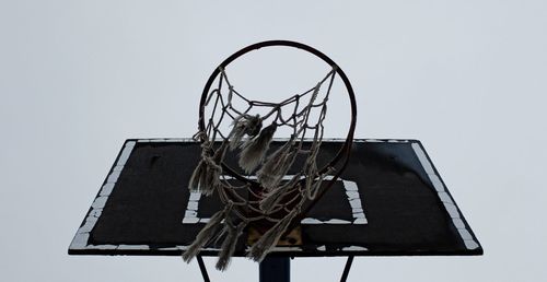 Low angle view of old basketball hoop against clear sky