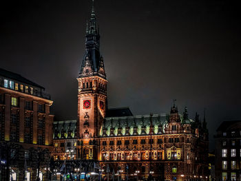 Low angle view of illuminated buildings against sky at night
