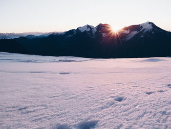 Scenic view of frozen landscape against sky during sunset