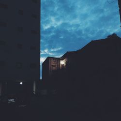 Silhouette houses against sky at night