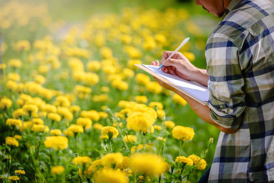 Woman holding yellow flowering plants