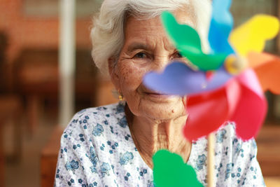 Portrait of woman with pinwheel at home