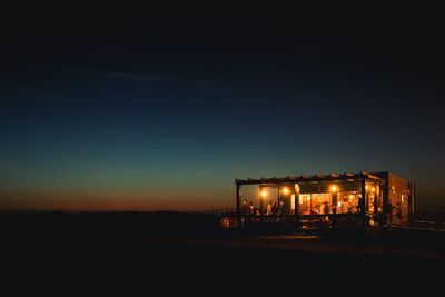 Illuminated built structure against sky at night