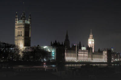 Illuminated buildings in city against sky at night