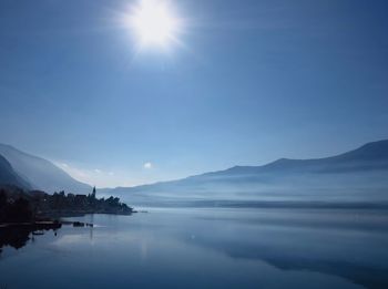 Scenic view of sea and mountains against blue sky