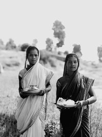 Young couple standing against sky