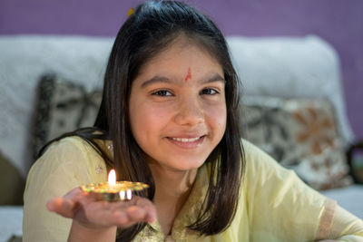 Portrait of a girl holding diya on the festive occasion of diwali