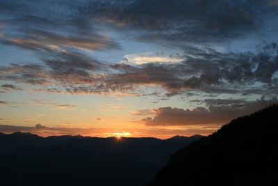 Scenic view of silhouette mountains against sky at sunset