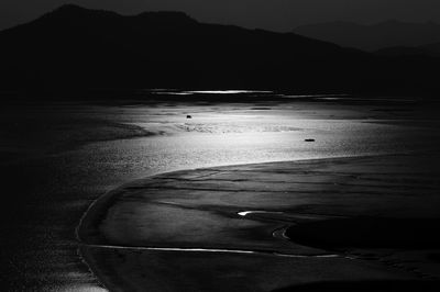 Scenic view of beach against sky at dusk