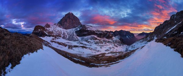 Panoramic view of snowcapped mountains against sky during sunset