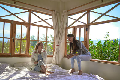 Woman sitting on bed in bedroom