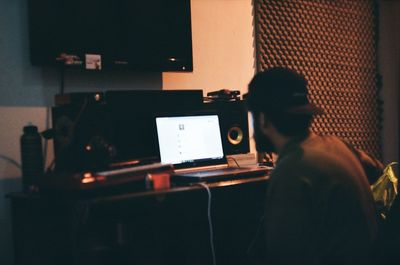 Rear view of man using laptop