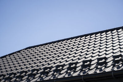 Low angle view of building roof against clear sky