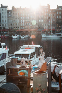 Boats moored in harbor against buildings in city