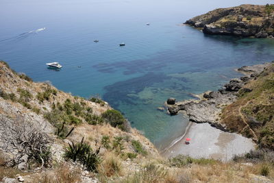 High angle view of sea by mountain against sky