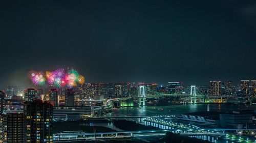 Illuminated cityscape against sky at night