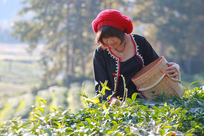 Portrait of young woman standing amidst plants