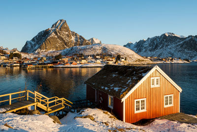 Houses by buildings against sky during winter