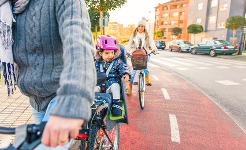 Family riding bicycles on street in city