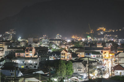 Illuminated cityscape against sky at night