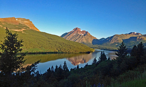 Scenic view of lake and mountains against clear sky