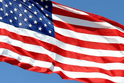 Close-up of american flag against sky